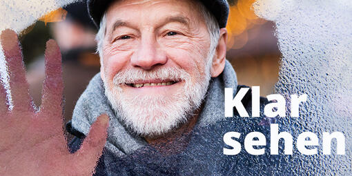 Motivbild der Woche des Sehens 2024. Ein älterer Mann hält seine Hand gegen eine Scheibe, die nur zum Teil klar ist.