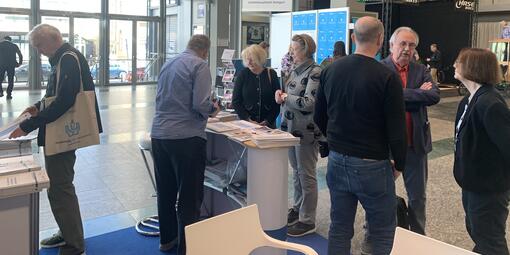 Personen finden sich am Messethresen ein und tauschen sich untereinander aus. 