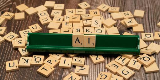 Das Foto zeigt Spielsteine mit Buchstaben. Es ist das Wort AI gelegt, das englische Wort für KI. 