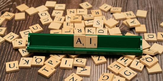 Das Foto zeigt Spielsteine mit Buchstaben. Es ist das Wort AI gelegt, das englische Wort für KI. 